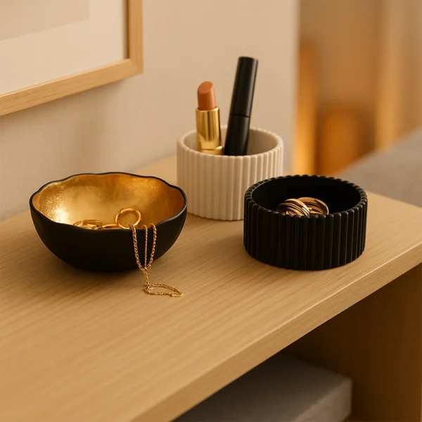Schale Luxus in Schwarz und Gold mit Schmuck auf hellem Sideboard im Wohnzimmer