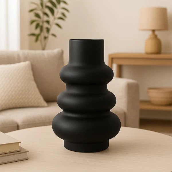 Vase Skulptural in Schwarz auf einem Wohnzimmertisch mit beiger Couch im Hintergrund