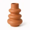 Vase Skulptural in Terrakotta mit weicher, gewellter Form auf hellem Hintergrund