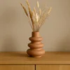 Vase Skulptural Terrakotta mit Trockenblumen auf Holzregal